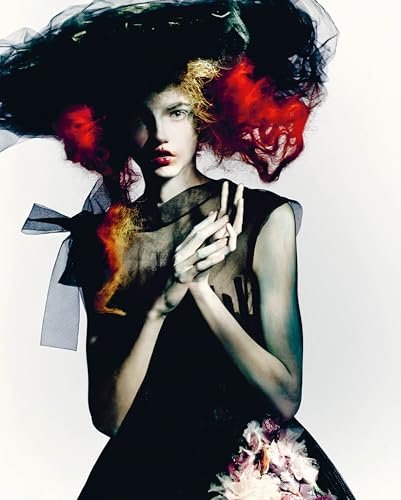 Woman with dramatic, voluminous hair and dark, artistic makeup.