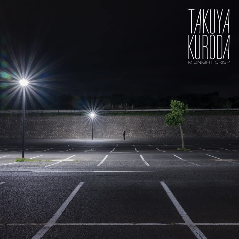 Nighttime parking lot with a lone figure under bright streetlights.