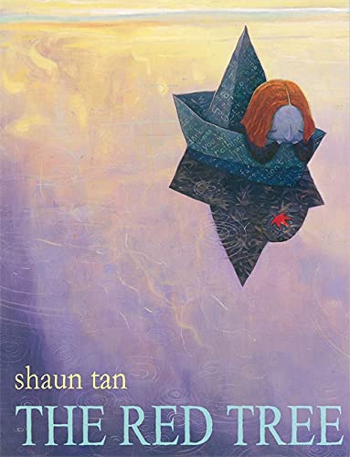 Child with red hair sits inside a dark, folded paper boat.