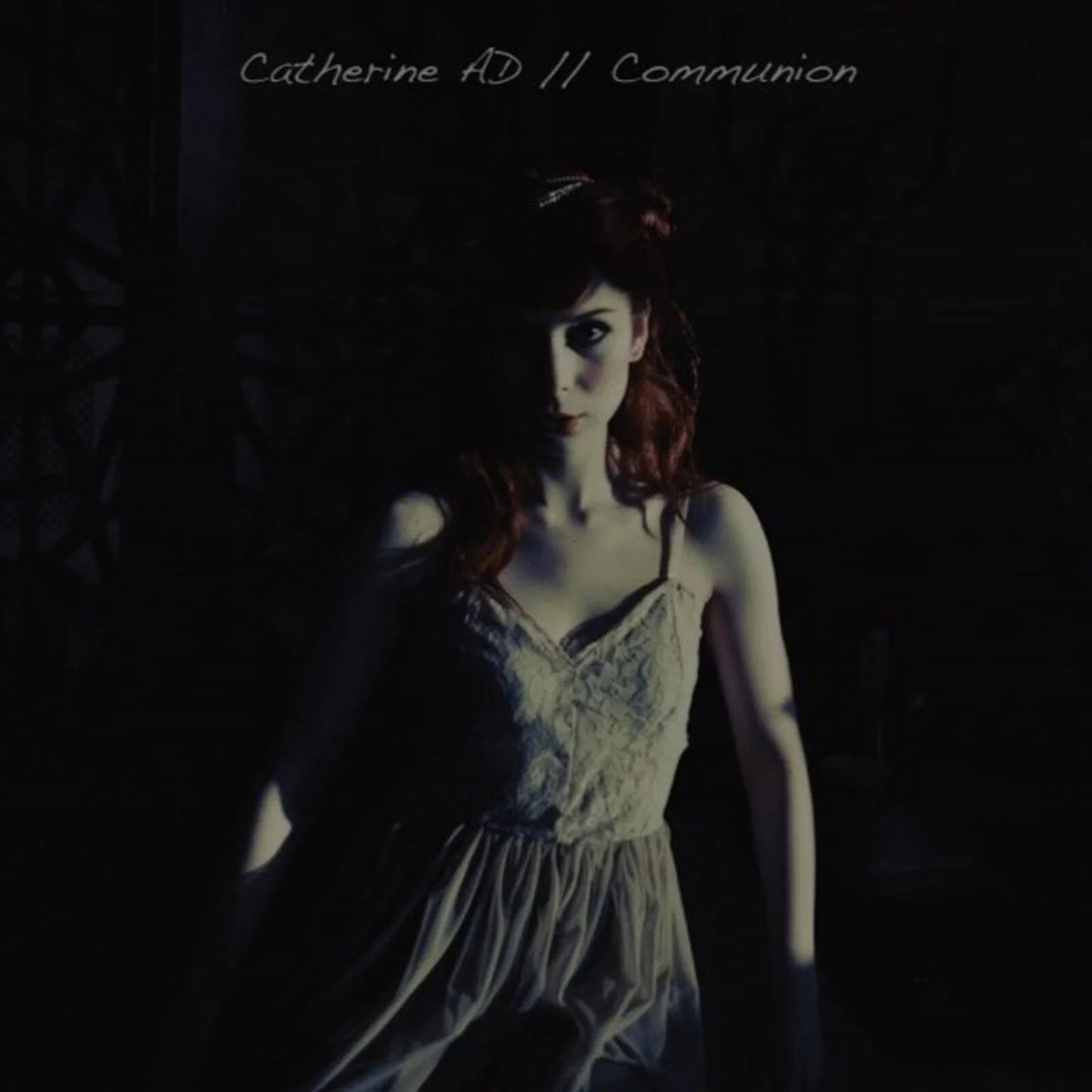 CD cover: woman with red hair in a dimly lit, shadowed portrait.
