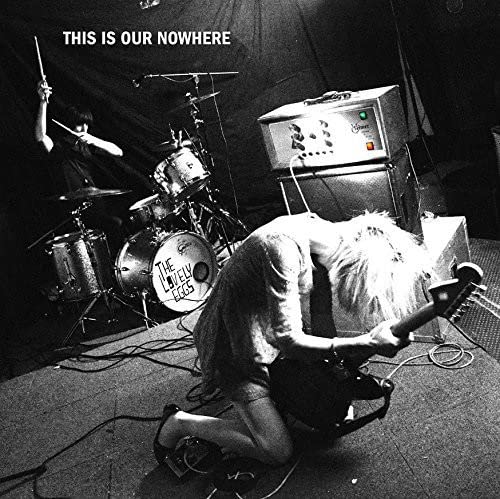 Black and white album cover featuring a band performing on stage.