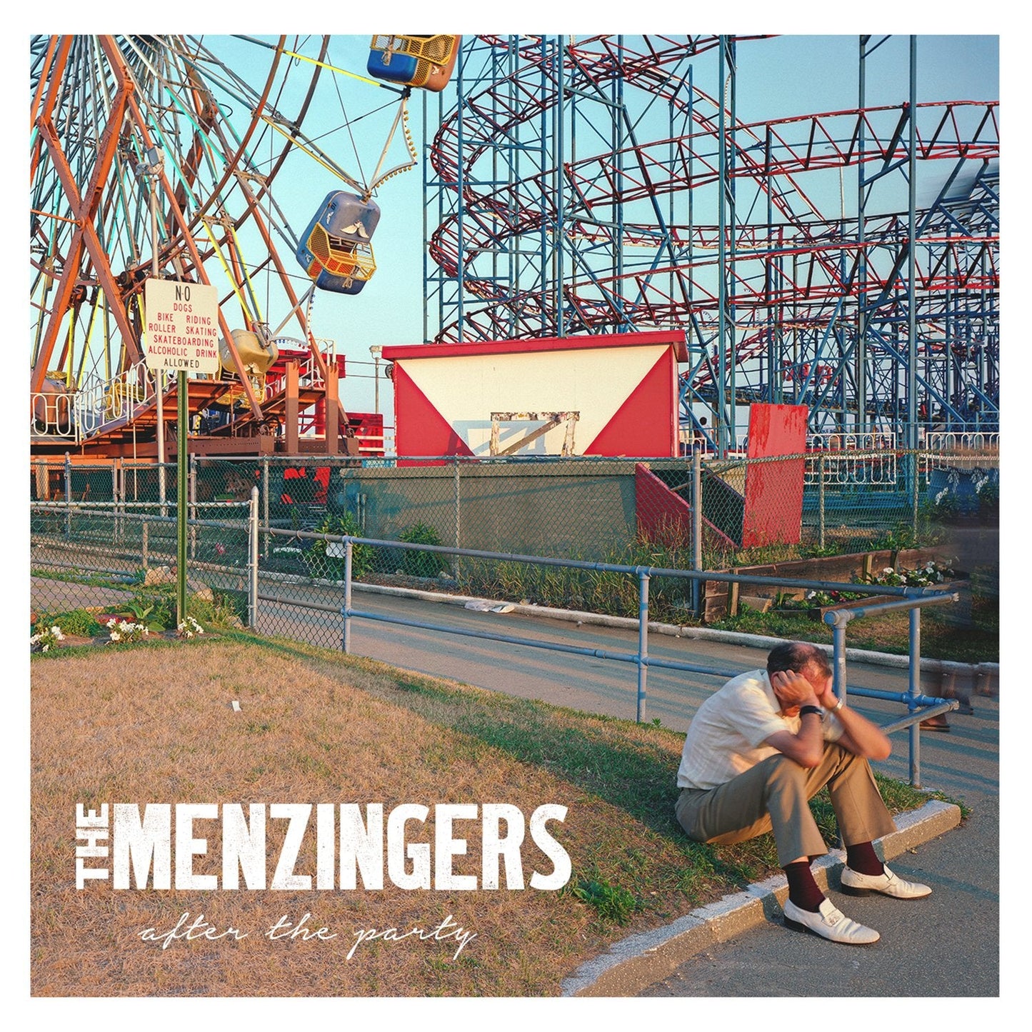 Album cover for The Menzingers: a man sits near an amusement park.