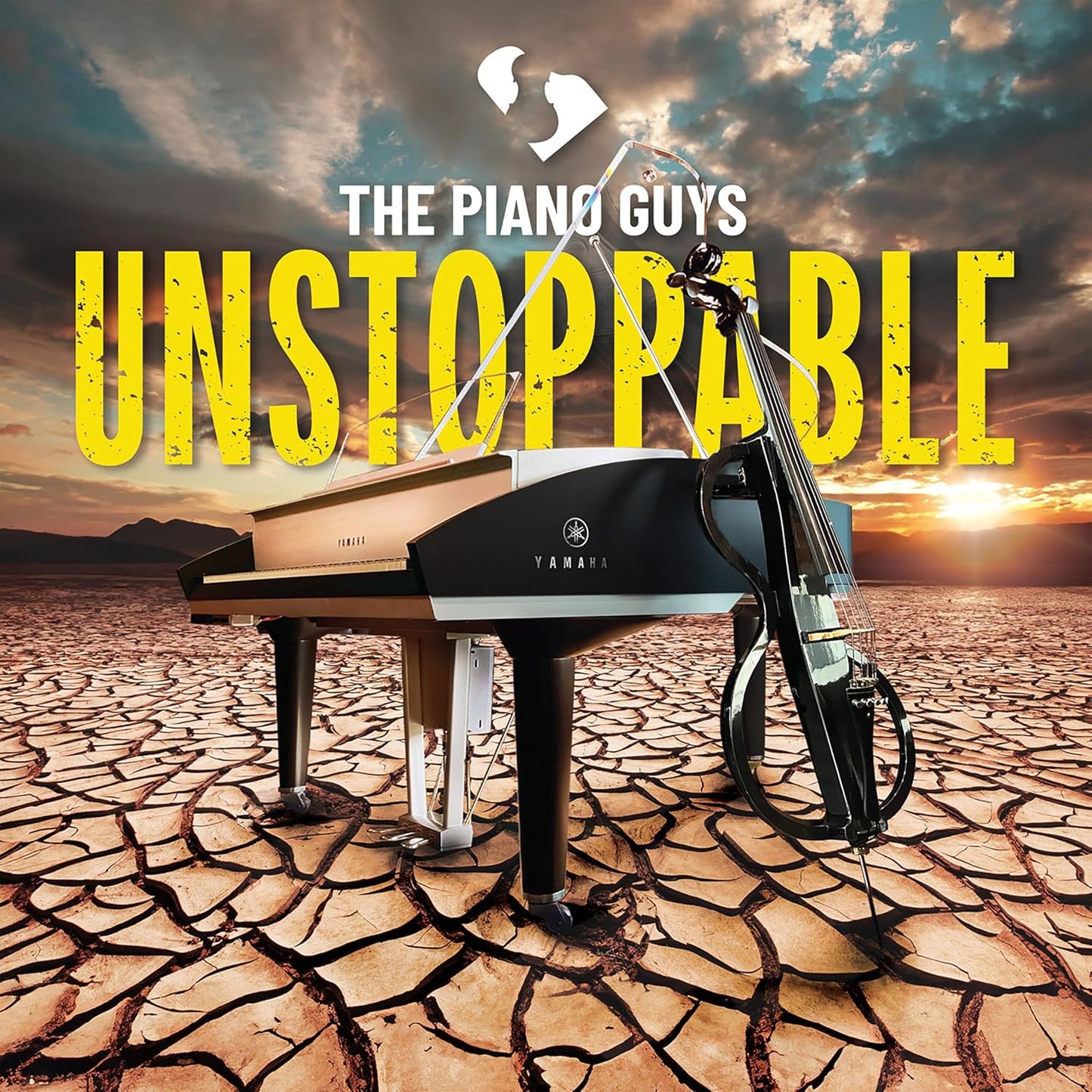Piano and cello on cracked earth under a dramatic sky.