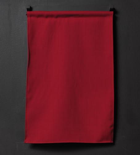 Solid red fabric panel hanging against a dark, textured wall.