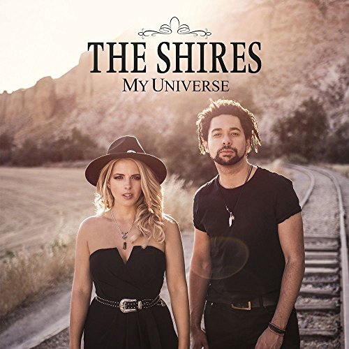 The Shires duo standing on a railroad track with a desert landscape in background.