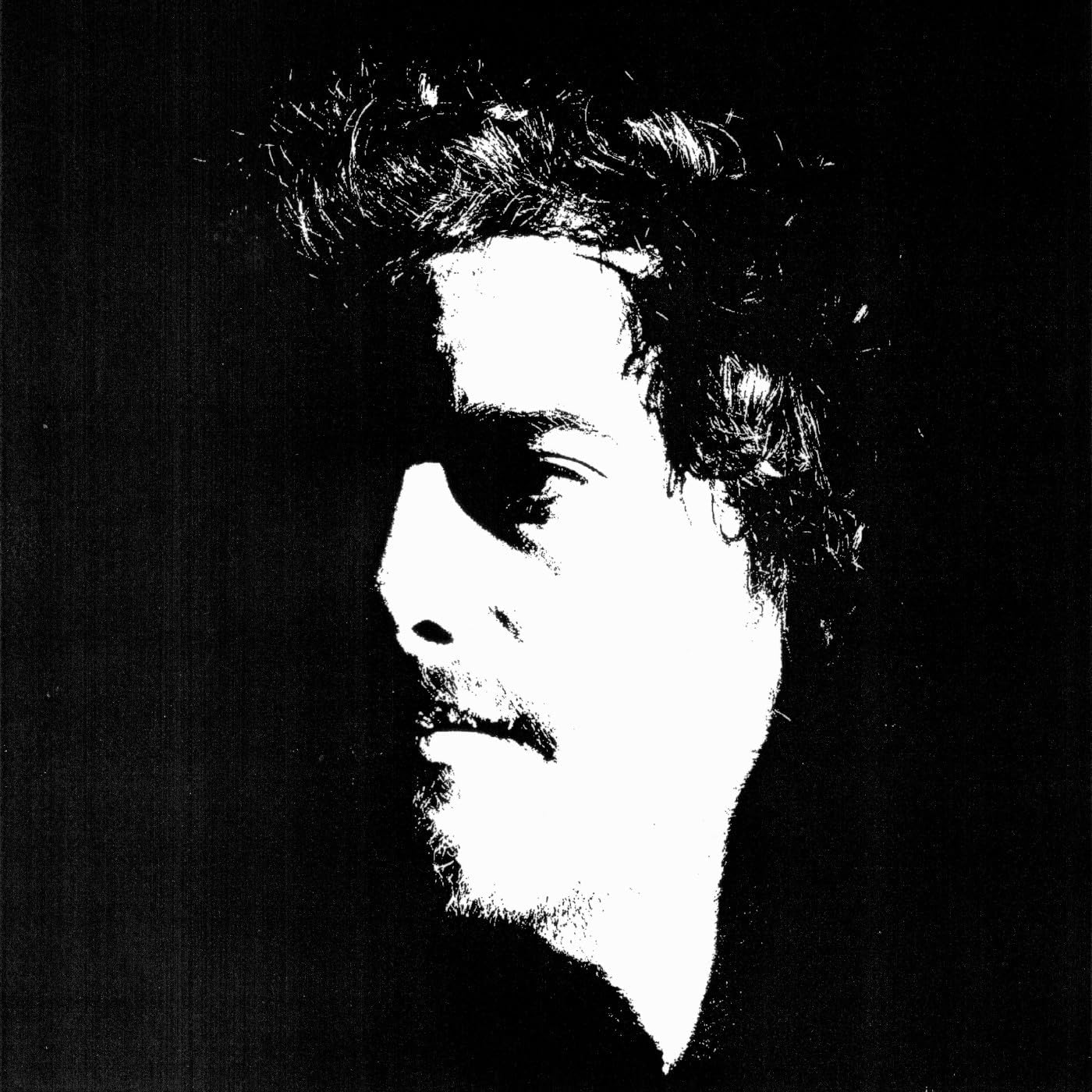 Black and white profile of a man with dark, curly hair.