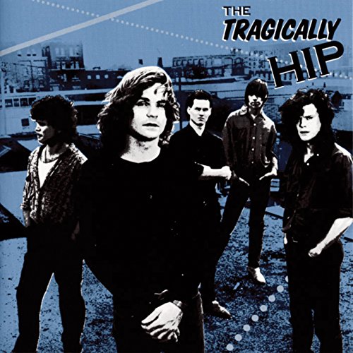 The Tragically Hip band portrait with a blue and grey industrial backdrop.