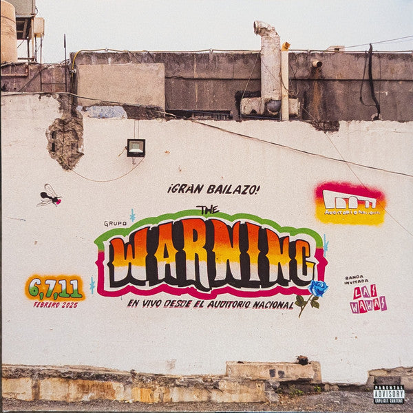 Graffiti on a white wall featuring The Warning logo and concert details.