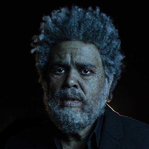 Close-up portrait of The Weeknd with graying curly hair and beard.
