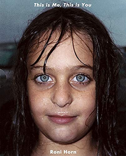 Close-up portrait of a young girl with wet dark hair and blue eyes.