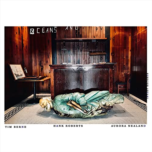 CD cover: statue in a wood-paneled room with a painting and chair.