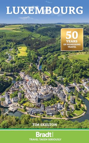 Aerial view of a town nestled in a river valley surrounded by lush green forests.
