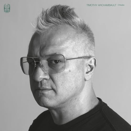 Black and white portrait of Timothy Archambault wearing glasses against a plain background.