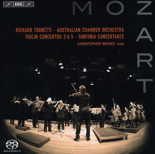 CD cover: orchestra performing, text “Mozart” vertically aligned, dark background.