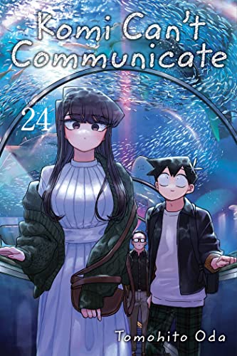 Komi and Tadano stand in an aquarium tunnel with fish swimming overhead.