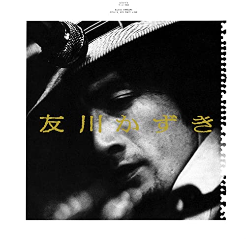 Black and white close-up portrait of Kazuki Tomokawa with gold Japanese text overlay.