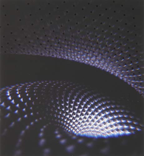 Abstract digital art featuring a dark, swirling pattern of glowing, textured, metallic-looking dots.