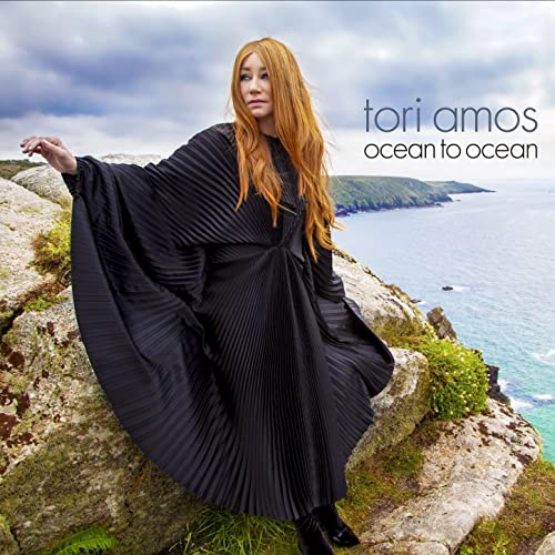 Tori Amos album cover, red hair, black dress, coastal landscape.