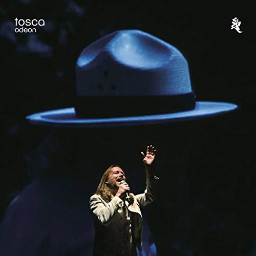 CD cover: a hat floats above a singer with raised hand.
