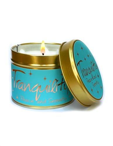 Blue and gold tin candle with a lit wick, labeled "Tranquility".
