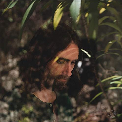CD cover featuring a man with long hair surrounded by foliage.