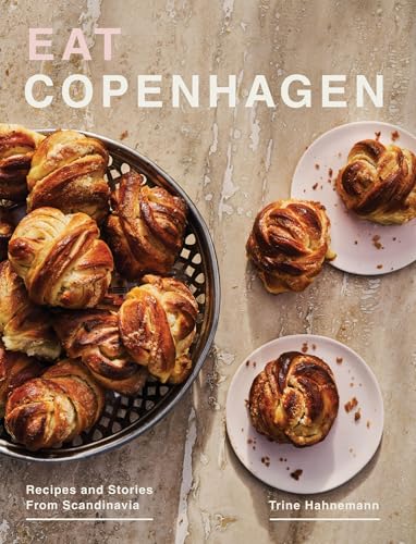 Book cover titled Eat Copenhagen showing a basket and plates of cinnamon buns.