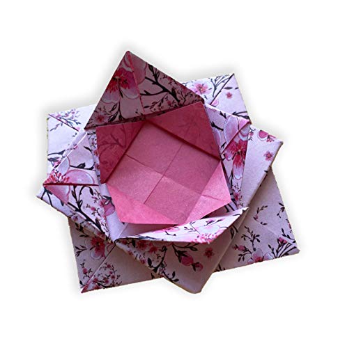 A folded origami lotus flower made of paper with a pink cherry blossom pattern.