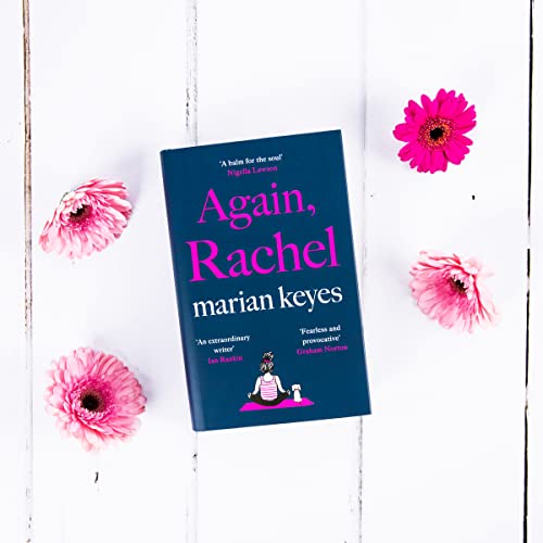 The book Again, Rachel by Marian Keyes surrounded by pink flowers on white wood.