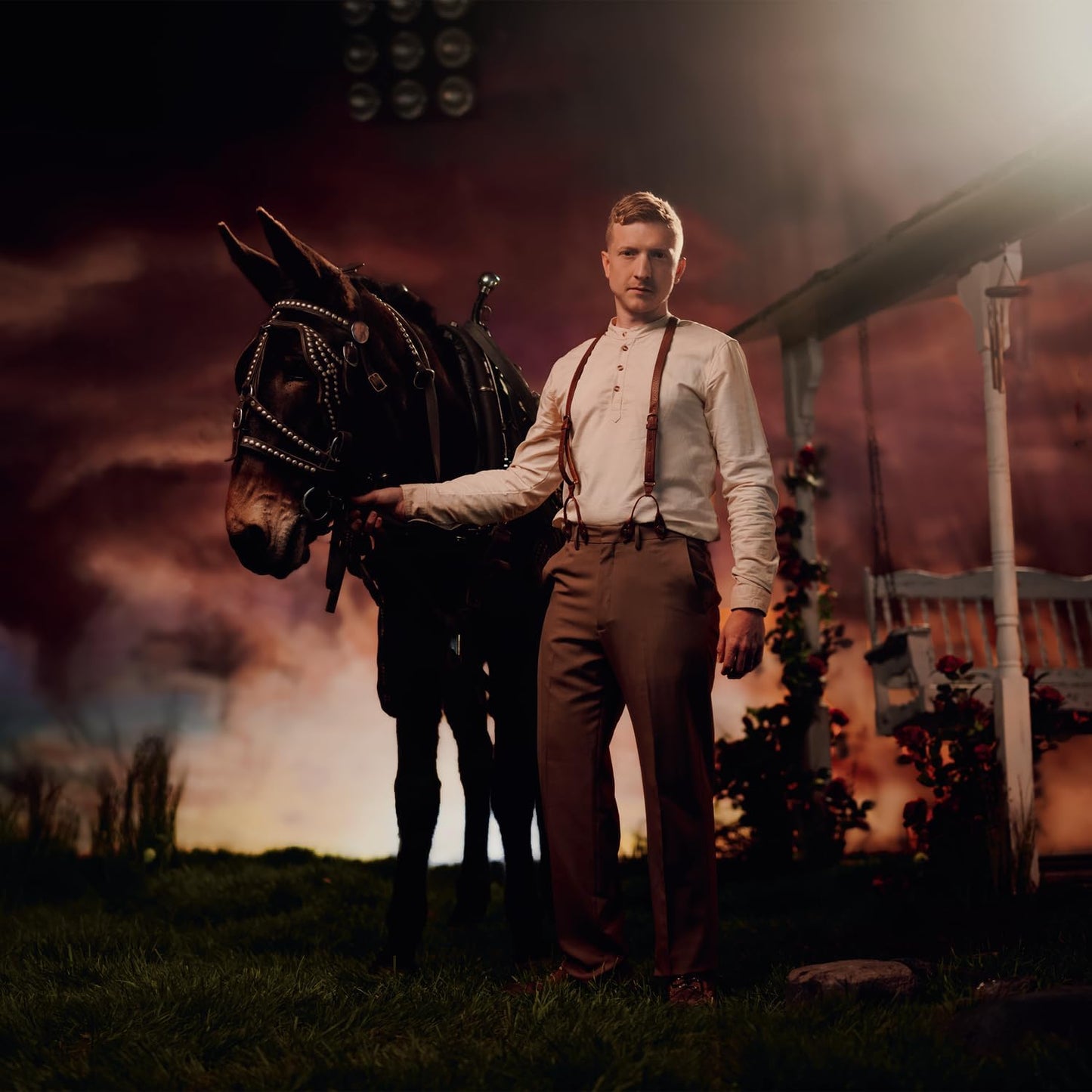 Tyler Childers stands with a mule in a rural, atmospheric setting.