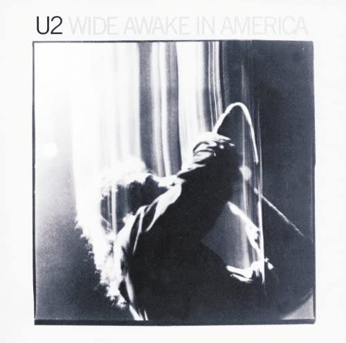 Black and white album cover showing a singer performing with a microphone on stage.
