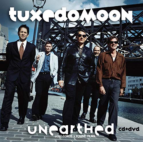 Tuxedomoon album cover featuring a band photo in front of a bridge.