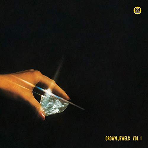 A hand holds a glowing diamond against a black background with yellow text.