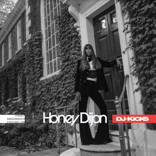 Black and white photo of Honey Dijon standing in a doorway with ivy.