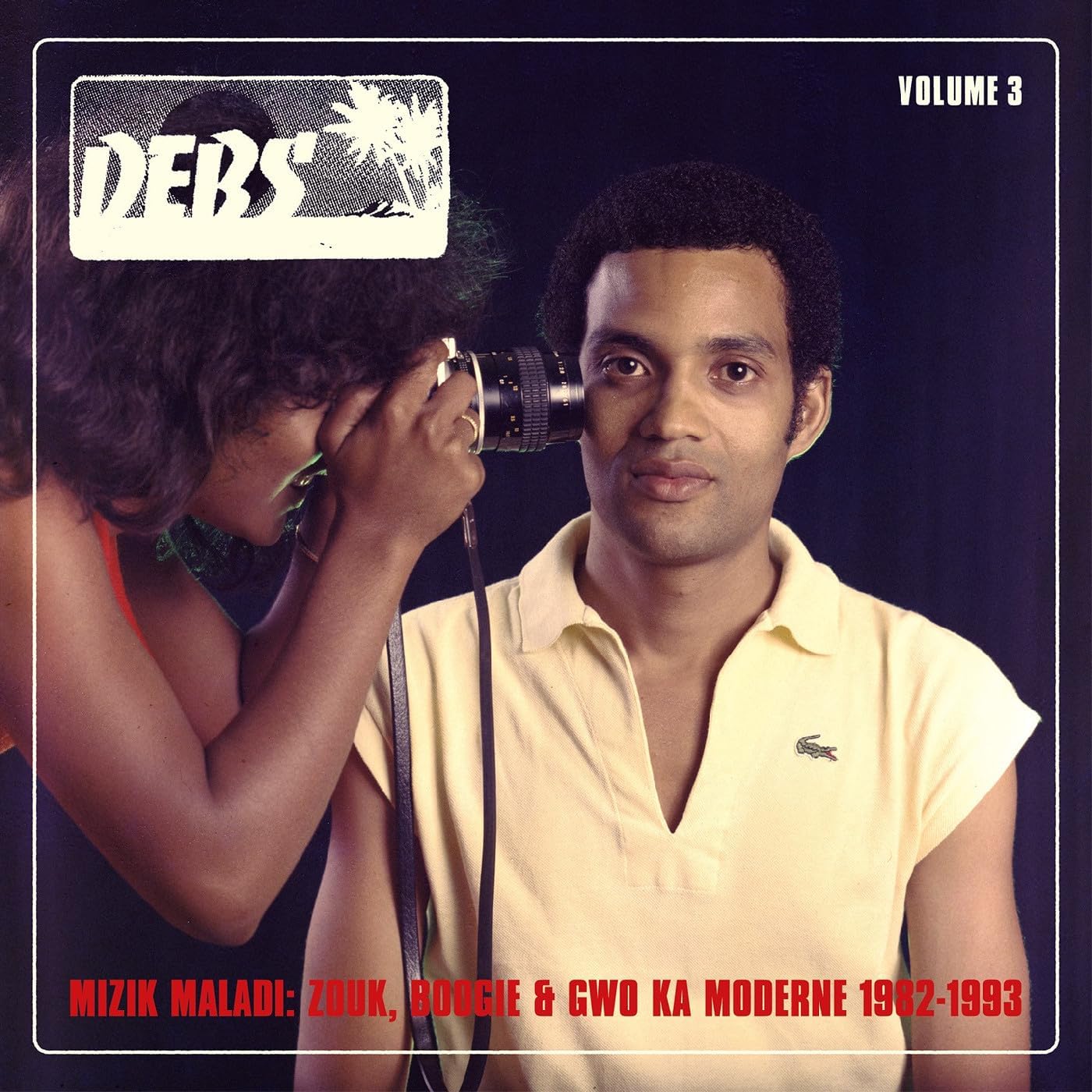 CD cover: man taking a photo, red and black text, “DEBS” logo.