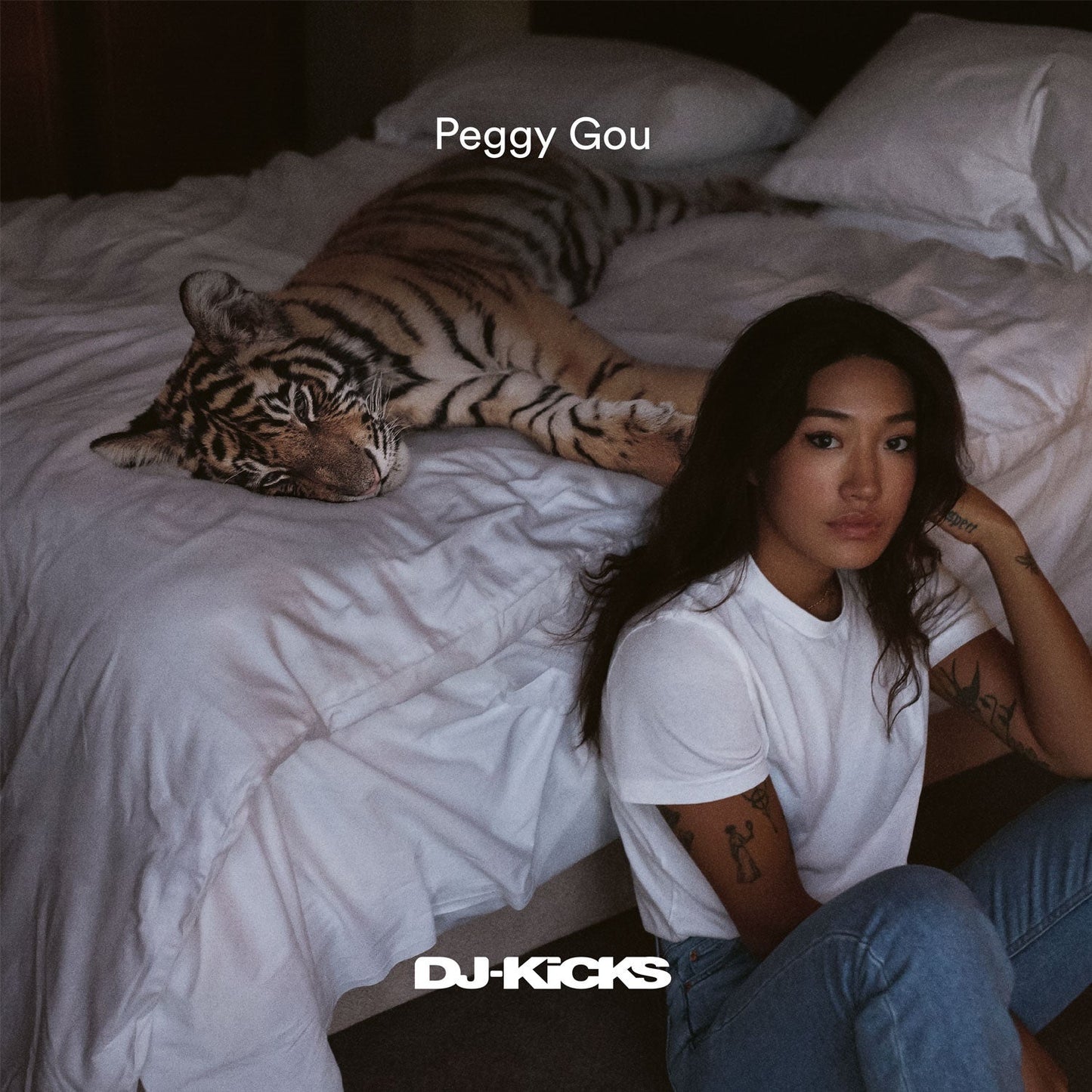 Album cover featuring Peggy Gou with a tiger on a white bed.