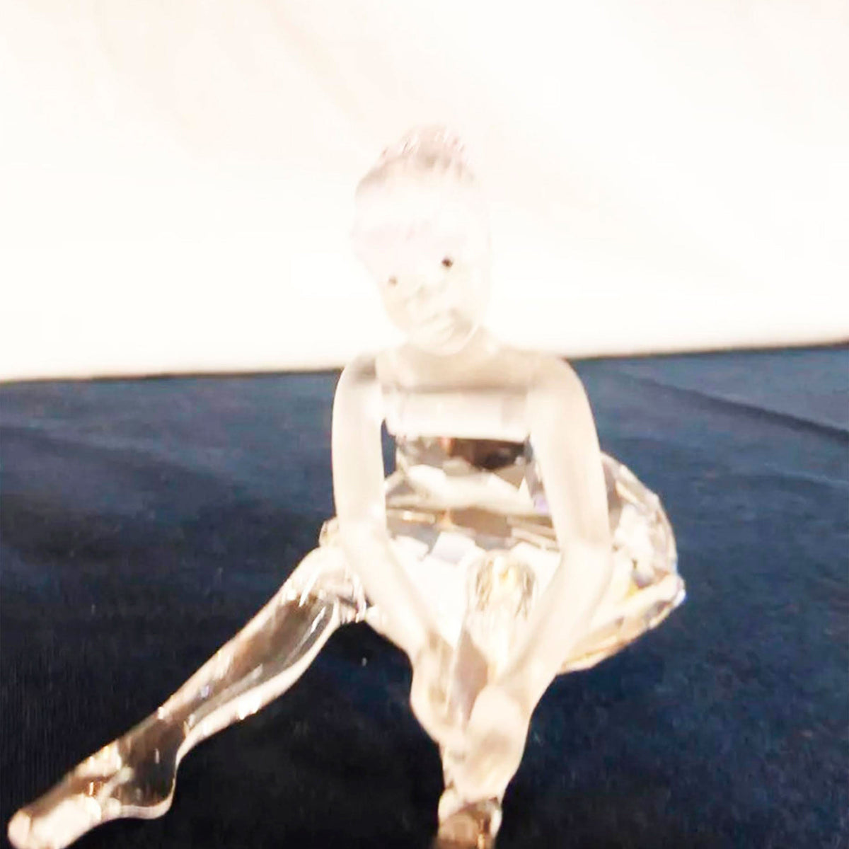 Ghostly, distorted image of a person squatting in a bright, washed-out scene.