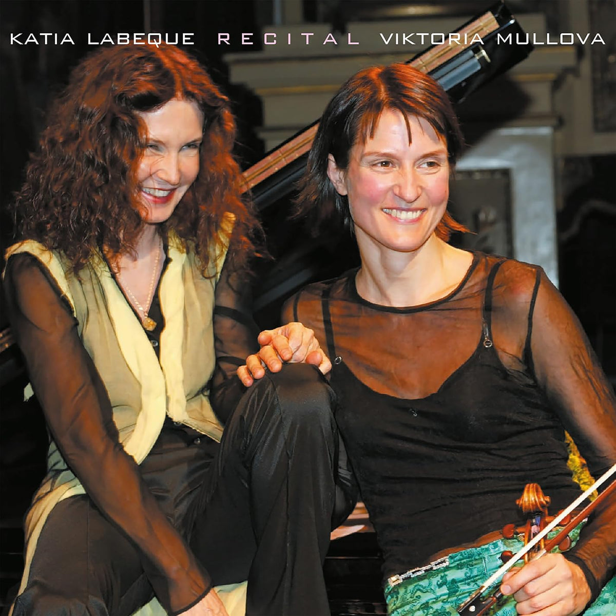 Viktoria Mullova and Katia Labèque, two smiling women with a violin and piano.