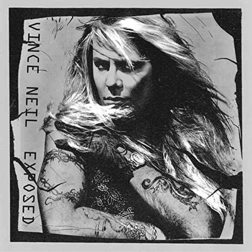 Black and white portrait of Vince Neil with long hair and arm tattoos.