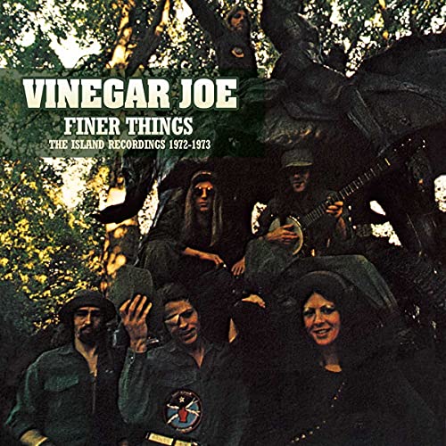 The band Vinegar Joe posing outdoors with text overlay on a dark, wooded background.