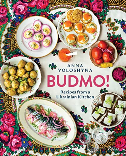 Cookbook “BUDMO!” with colorful Ukrainian food and floral patterned cloth.