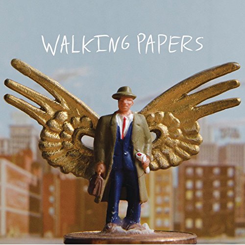 CD cover: winged figure in a suit stands before a cityscape.