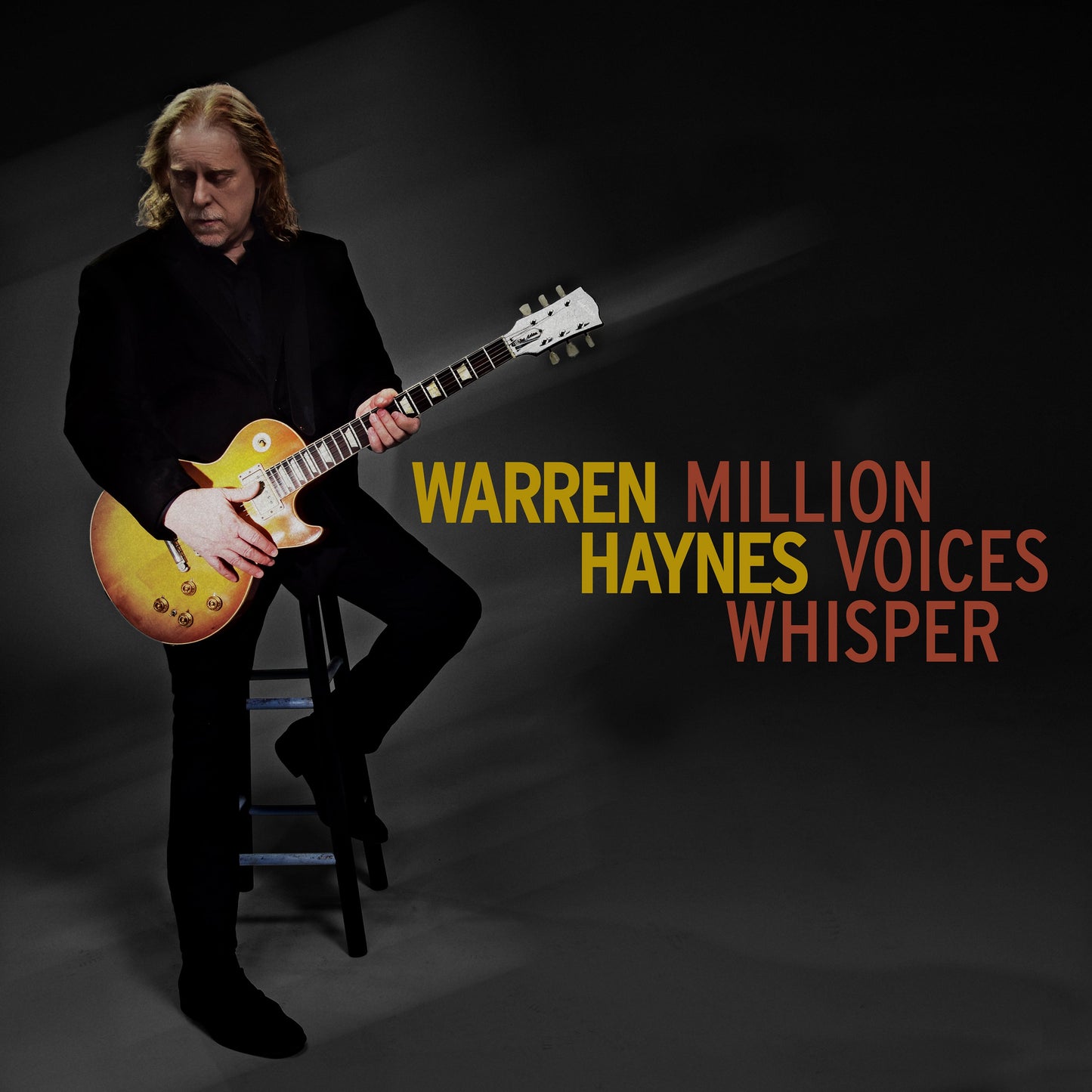 Warren Haynes seated, playing a sunburst electric guitar, album cover.