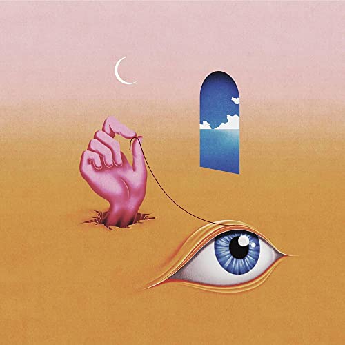Hand emerging from ground, holding string towards eye and distant seascape.