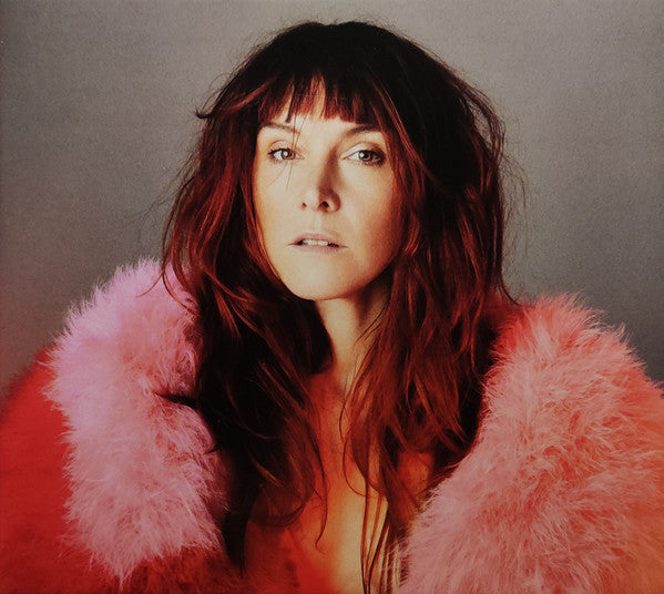 Woman with long red hair wearing a pink feather boa.
