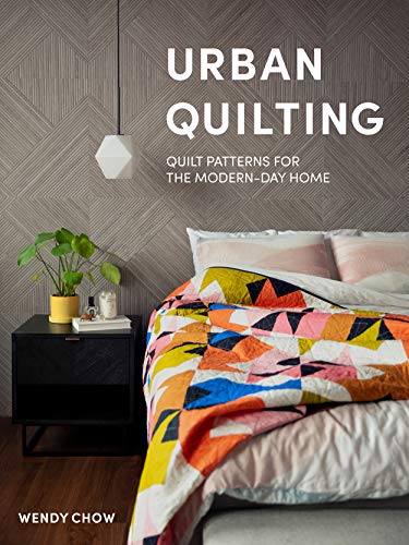 Book cover featuring a colorful quilt on a bed in a modern bedroom.