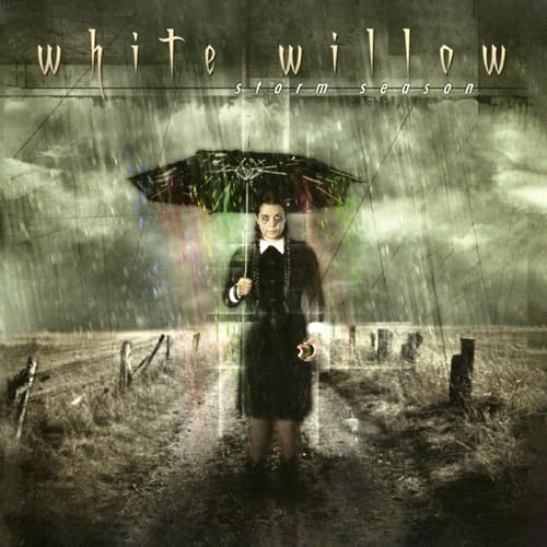 Woman with umbrella in a rainy, desolate field; album cover.