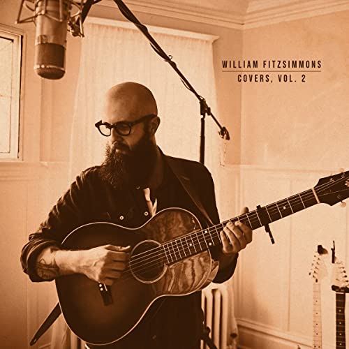 William Fitzsimmons playing acoustic guitar in a recording studio, sepia tone.