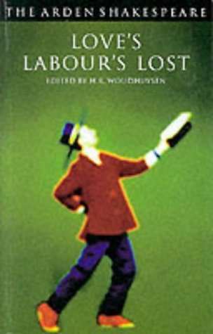 A man in a red jacket and purple pants holds a book on green cover.
