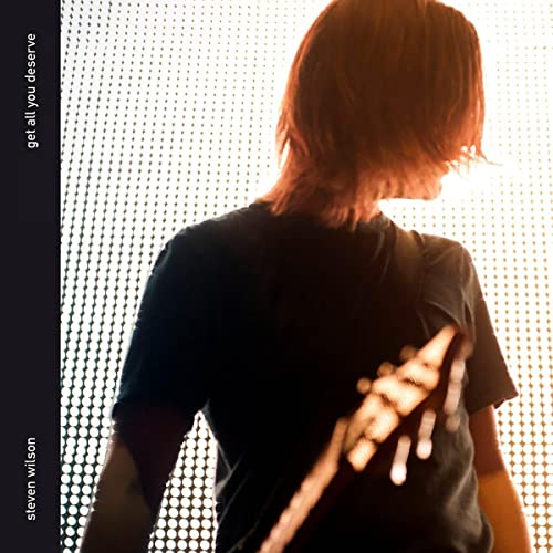 CD cover: black background, rear view of a man with reddish hair.