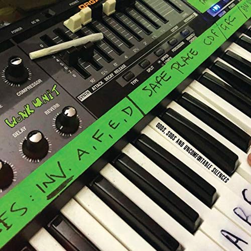 CD case resting on a black synthesizer keyboard with green lettering.